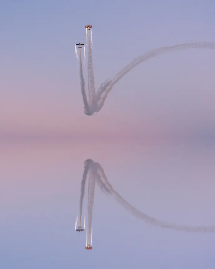 Photographie de voltige aérienne symétrique sur l'eau au coucher de soleil par Nathan Viel Photographie