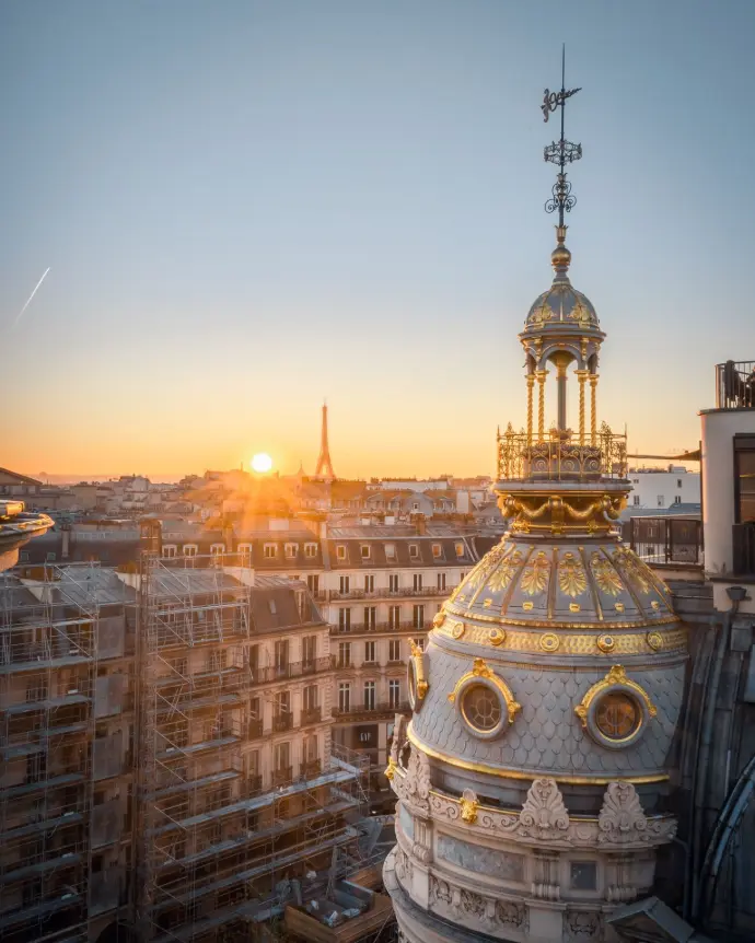 Photographie des toits de Paris, de la tour Eiffel et du Printemps au coucher de soleil